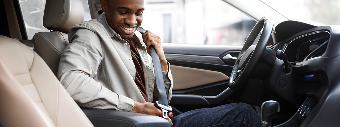 Man putting on seatbelt in car