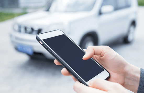 driver with phone and car in background
