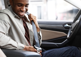 Man putting on seatbelt in car