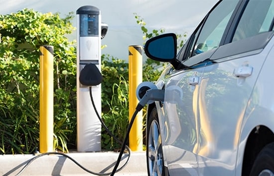 White electric vehicle charging in parking lot